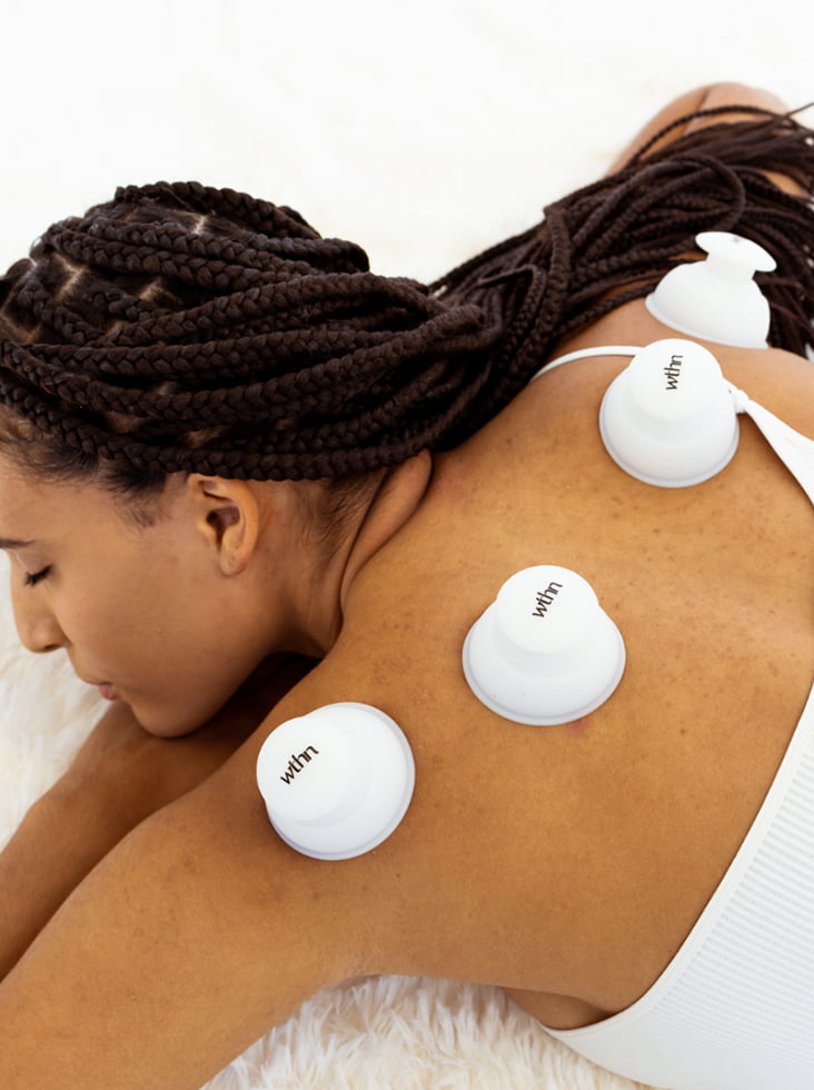 Woman working from home at a makeshift desk with poor posture, experiencing neck and shoulder pain from tech neck